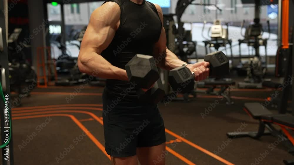Bodybuilder guy crop view doing dumbbell bicep tricep curls workout in gym, bodybuilding Bodybuilder guy crop view doing dumbbell bicep tricep curls workout in gym, bodybuilding