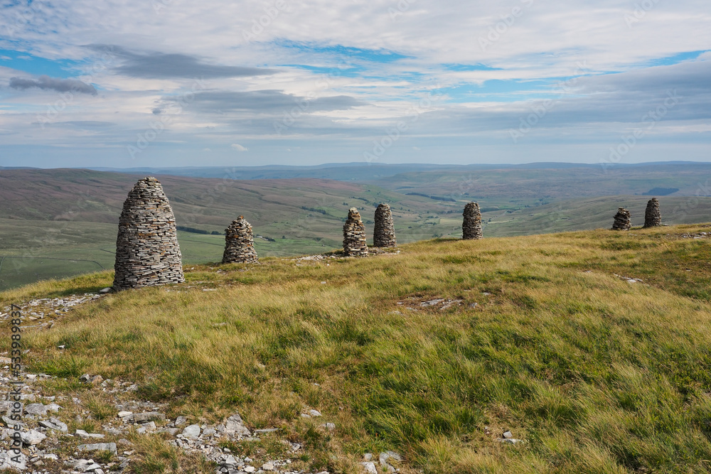 Multiple cairns standing tall at the summit of High White Scar, next to Wild Boar Fell, overlooking the Eden Valley, Cumbria, UK - obrazy, fototapety, plakaty 