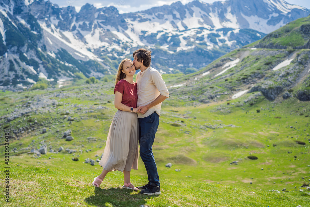 Naklejka premium Couple tourists man and woman in Mountain lake landscape on Durmitor mountain in Montenegro beautiful Durmitor National park with lake glacier and reflecting mountain