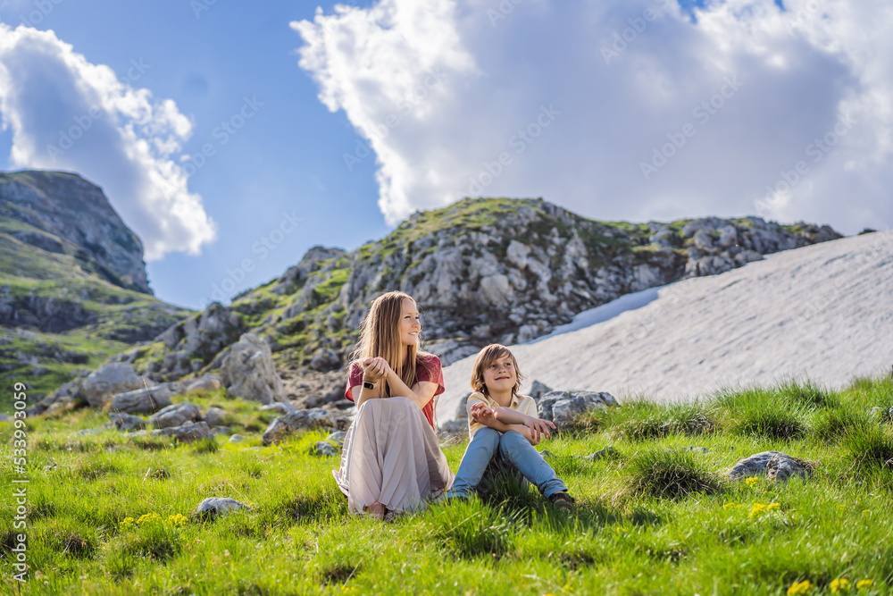 Family of tourists mom and son in Mountain lake landscape on Durmitor mountain in Montenegro beautiful Durmitor National park with lake glacier and reflecting mountain Portrait of a disgruntled girl