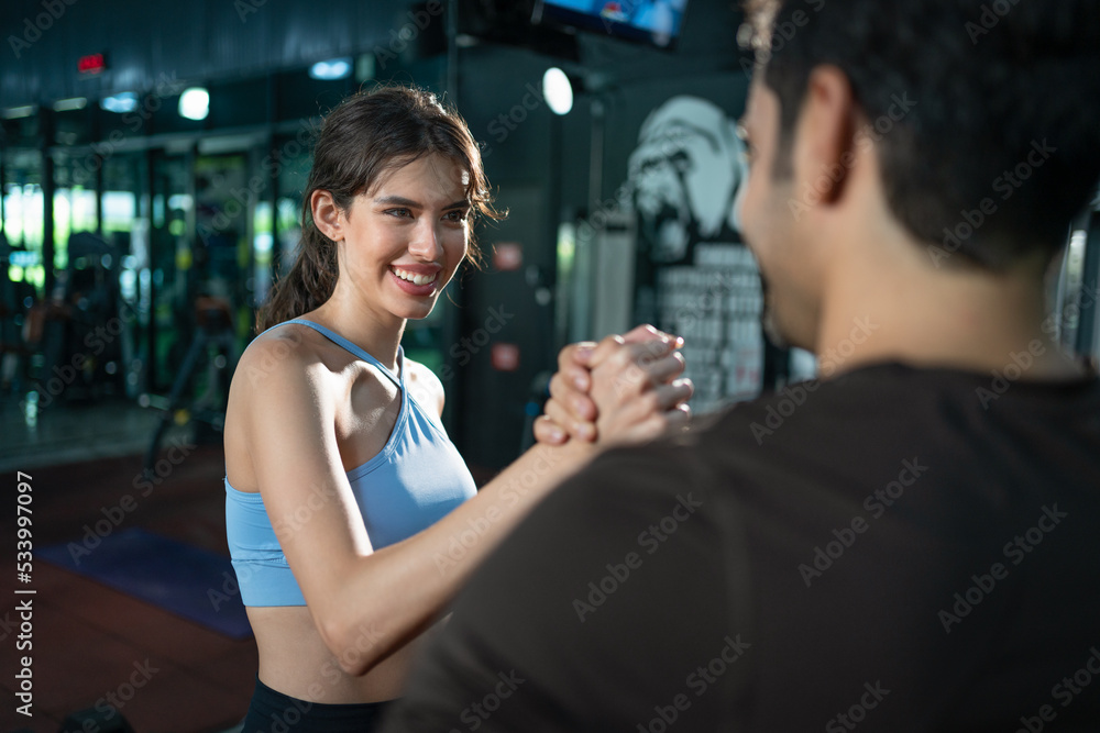 Smiling woman athlete in sportswear relaxing and handshake with her
