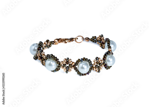 Women's bracelet, woven of gold white beads and pearls. Isolated on a white background.