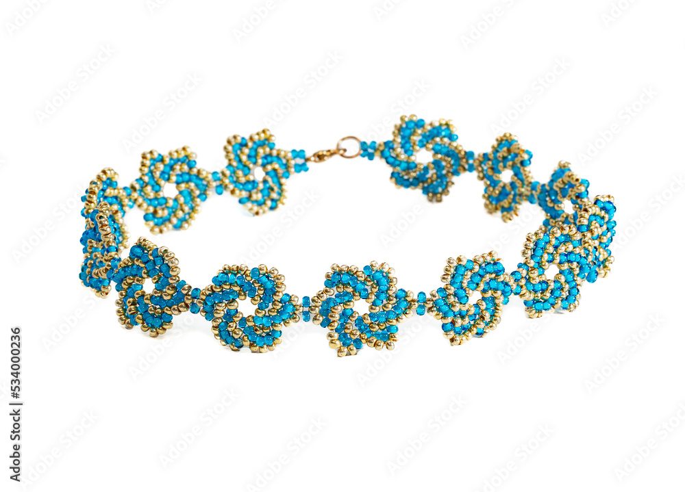 Women's bracelet, woven of gold and blue beads. Isolated on a white background. Women's bracelet, woven of gold and blue beads. Isolated on a white background.