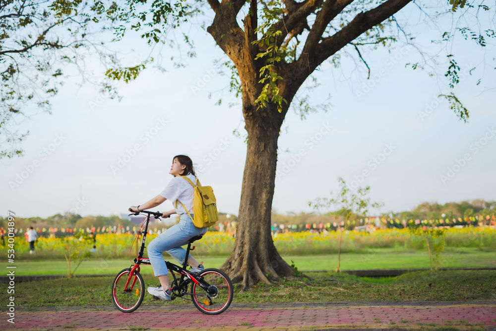 spring is comming concept with happy and cheerful feeling of asian woman riding bicycle