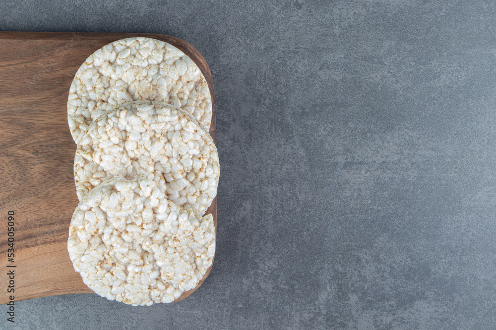 A wooden cutting board with puffed rice bread A wooden cutting board with puffed rice bread