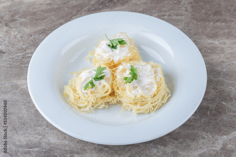 Spaghetti, yogurt and green vegetable on the plate , on the marble background