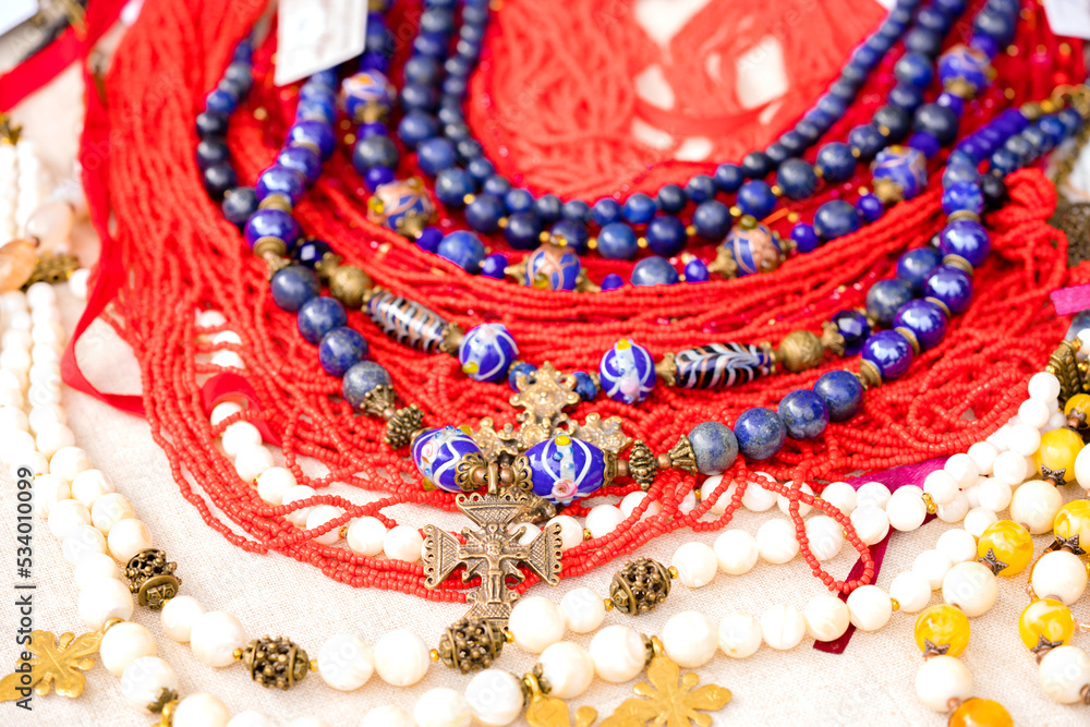 Ukrainian ethnic style jewellery made with glass beads and metal crosses. Exclusive handmade necklaces at souvenir stall or street Sunday market. Selective focus