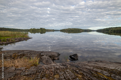 Tranquil landscape of lake stony coast with grass