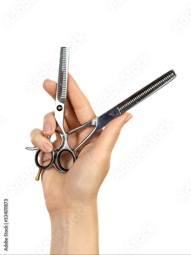 The hand holds a pair of professional hairdressing scissors for thinning. Isolated on white background. Close-up