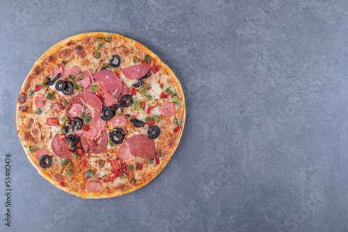 Top view of pepperoni pizza. On grey background