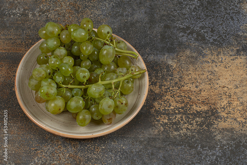 Fresh green grapes on ceramic plate