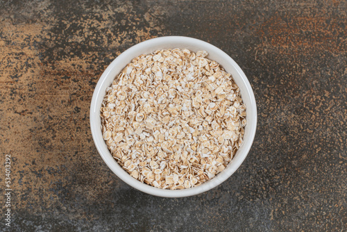 Dry oat flakes in white bowl
