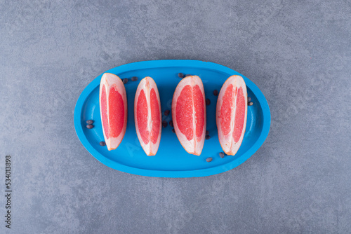 Top view of fresh grapefruit slices on blue wooden board