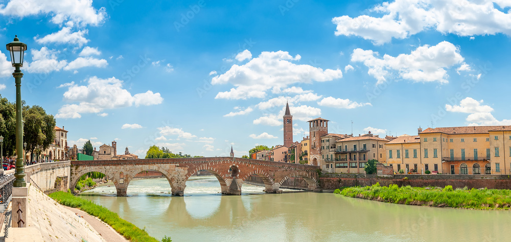 Panorama of the Ponte Pietra bridge and the city of Verona on the banks of the river with historical buildings and towers, Italy, Europe
