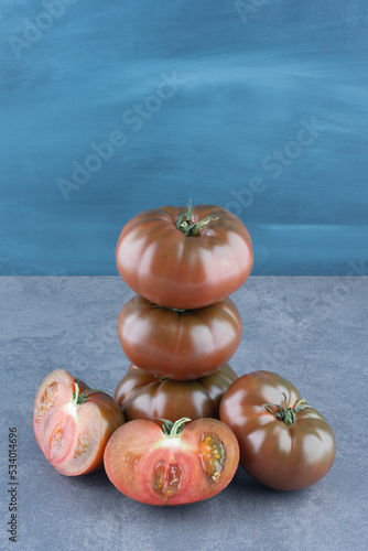 Organic fresh whole and sliced tomatoes on marble background
