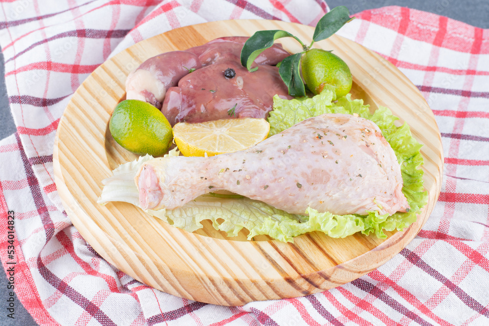 Raw chicken leg and beef on wooden plate Raw chicken leg and beef on wooden plate