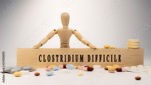 clostridium difficile disease. Written on wooden surface. On wood and medicine concept. white background. Diseases and treatments photo