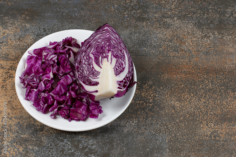 A plate of cut red cabbage, on the plate , on the marble background