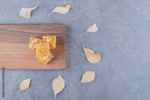 Yellow traditional turkish delight (rahat lokum) with peanuts on wooden cutting board