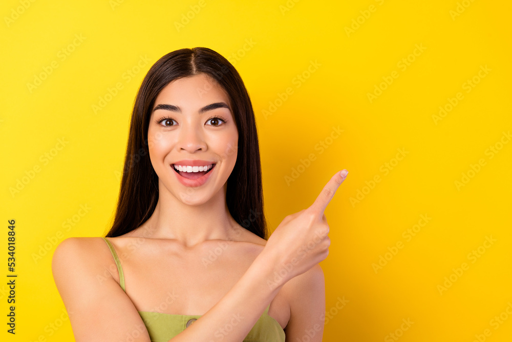 Photo of pretty imressed young lady wear green outfit pointing empty space isolated yellow color background Photo of pretty imressed young lady wear green outfit pointing empty space isolated yellow color background