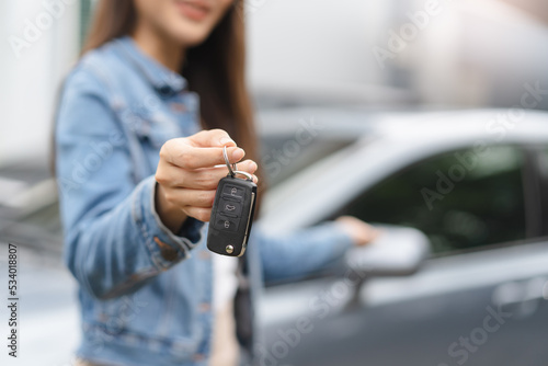 transportation rental automotive business concept. Close up hands of rental auto agent giving car remote key to client to travel sightseeing.