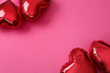 Red heart shaped balloons on pink background, flat lay with space for text. Saint Valentine's day celebration