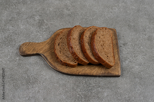 Black bread slices on wood board