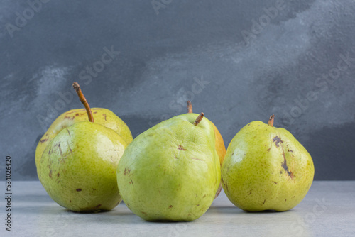 Pile of green pears on grey background