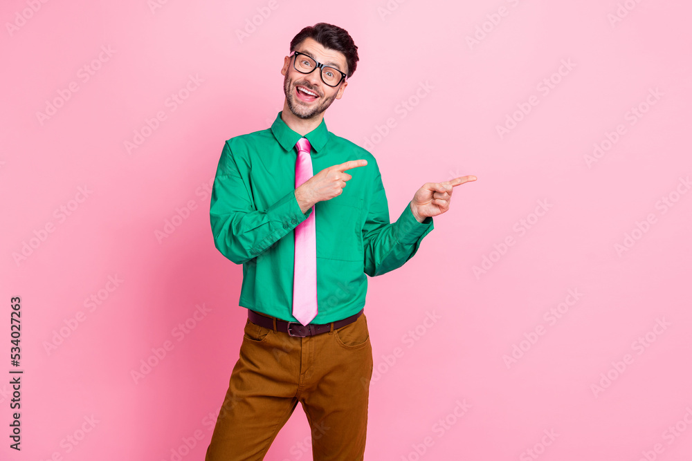 Portrait of young office manager funny guy directing fingers empty space new vacancy work isolated on bright pink color background Portrait of young office manager funny guy directing fingers empty space new vacancy work isolated on bright pink color background
