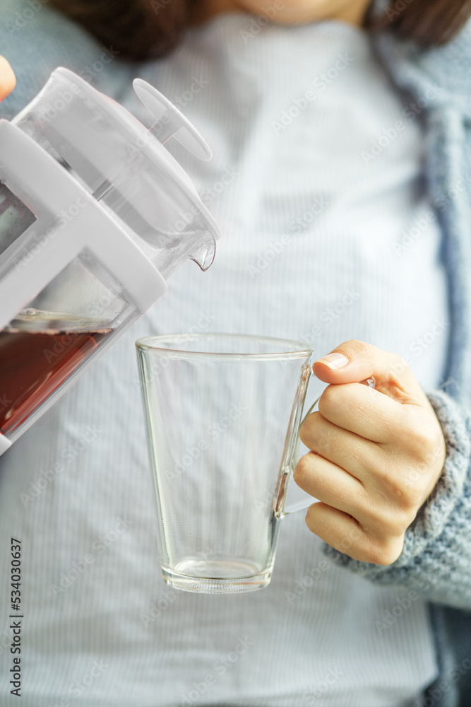 Close-up of woman pouring hot tea into a cup. Beverage concept, lifestyle, autumn and winter. Close-up of woman pouring hot tea into a cup. Beverage concept, lifestyle, autumn and winter.