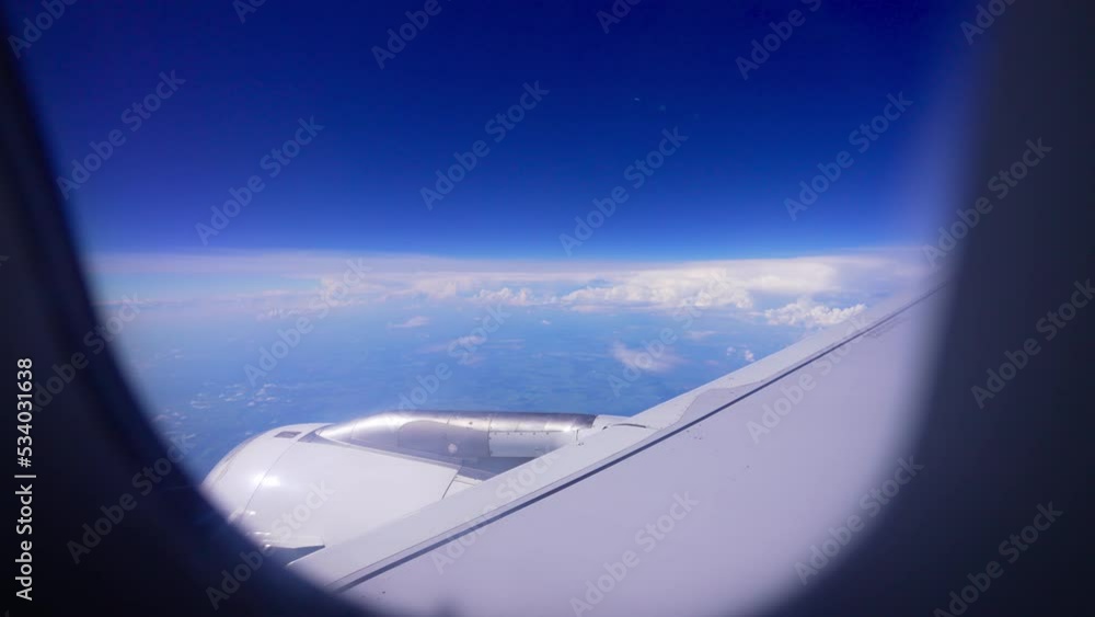 View from airplane window over white clouds and blue sky. Aerial view of city or town and nature from bird eye view. Beauty in nature landscape. Sun rays. Heaven. Altitude at level of stratosphere. View from airplane window over white clouds and blue sky. Aerial view of city or town and nature from bird eye view. Beauty in nature landscape. Sun rays. Heaven. Altitude at level of stratosphere.