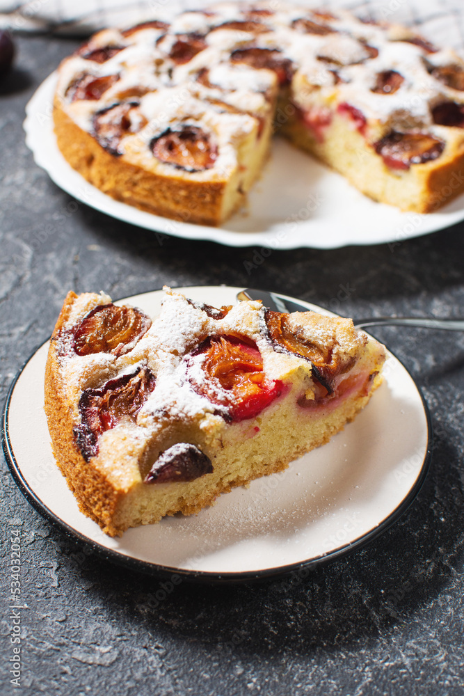Homemade delicious plum tart with with sugar powder on black stone table Homemade delicious plum tart with with sugar powder on black stone table