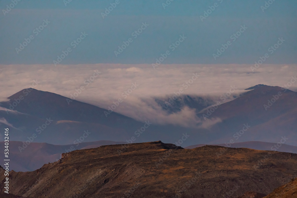 Panoramic view form mountains peak on the fog and clouds. Sunrise landscape. 