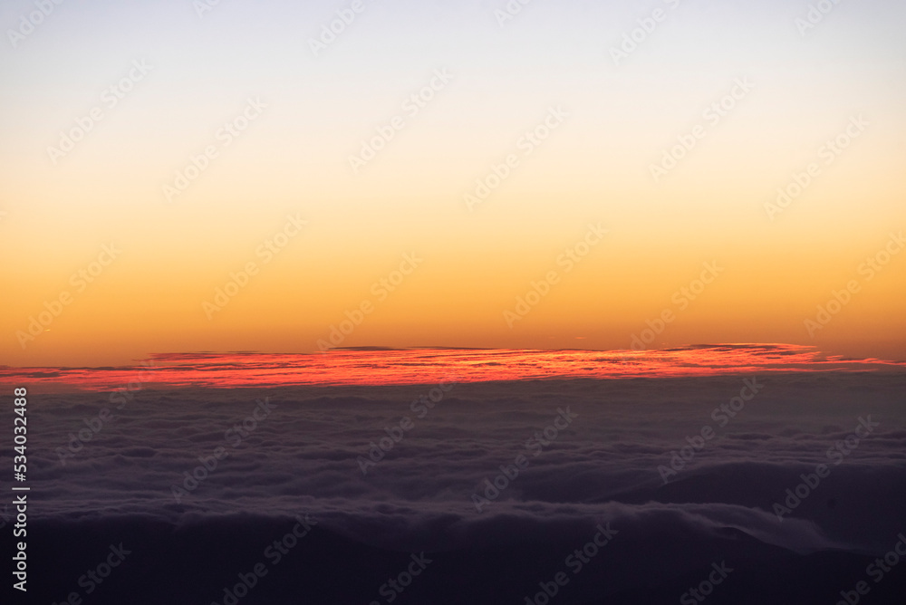 Panoramic view form mountains peak on the bright sunset  with clouds.