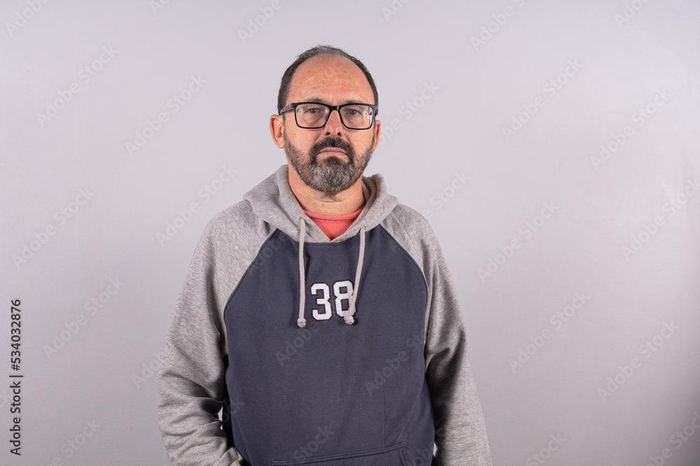 Close-up man in his 60s wearing eyeglasses, against gray wall background with copy space Close-up man in his 60s wearing eyeglasses, against gray wall background with copy space