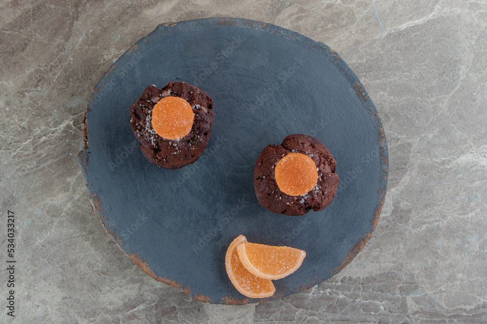 Two chocolate brownies with marmalades on wooden piece