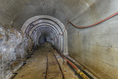 Tunnel of closed coal mine with railway track.