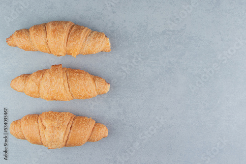 Three flavorful croissant , on the marble background
