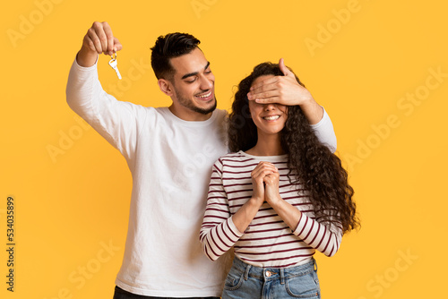 Smiling Arab Man Holding Home Keys And Surprising His Excited Girlfriend