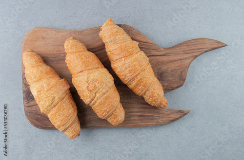 Flavorful croissant on board   on the marble background