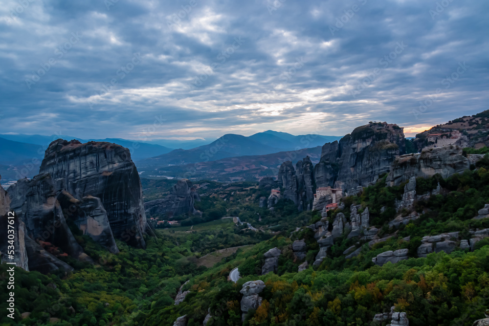 Main observation deck of Meteora with panoramic view of smooth rock pinnacles formation and Holy Eastern Orthodox Monasteries, Kalambaka, Meteora, Thessaly, Greece, Europe. Dramatic evening landscape