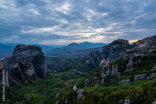 Main observation deck of Meteora with panoramic view of smooth rock pinnacles formation and Holy Eastern Orthodox Monasteries, Kalambaka, Meteora, Thessaly, Greece, Europe. Dramatic evening landscape