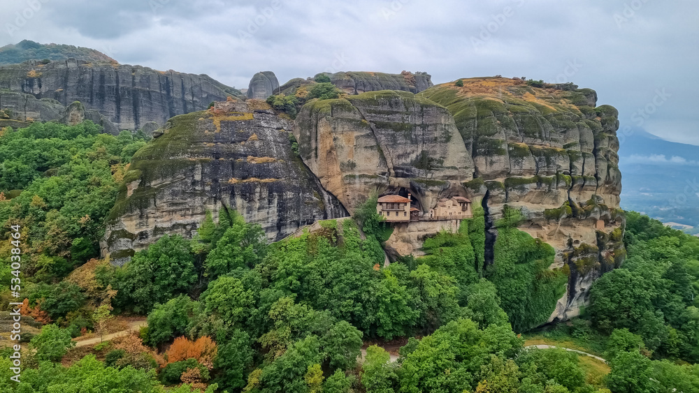 Cliff dwelling house or Ypapanti Monastery near Kalambaka, Meteora, Thessaly, Greece, Europe. Built into a cliff face and not easy to reach. Foggy rainy day creates mystical atmosphere. Rock formation