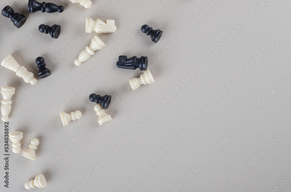 Chess pieces scattered all over on marble background Chess pieces scattered all over on marble background