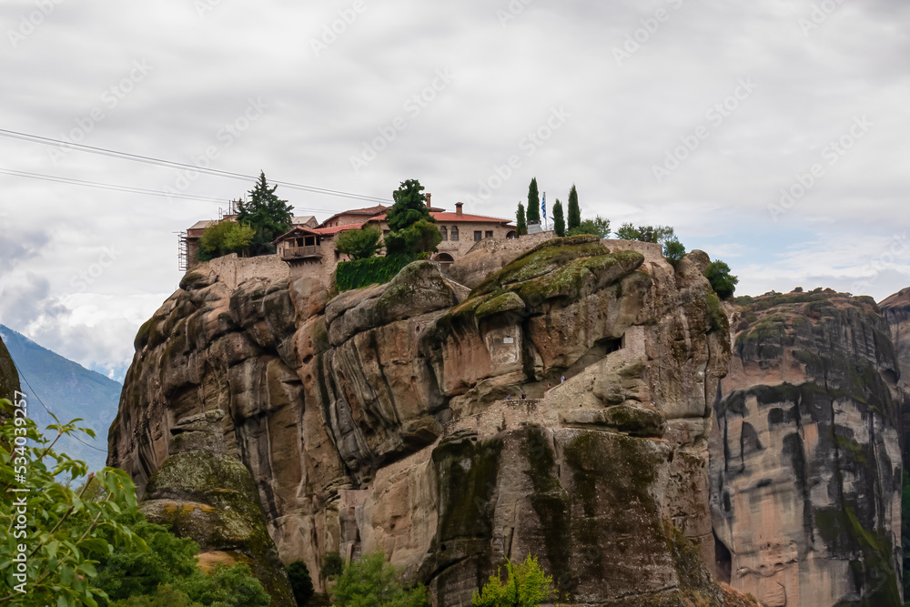 Scenic view of Holy Trinity Monastery (Agia Triada, Ayias Triadhos, Ayia Triada) near Kalambaka, Meteora, Thessaly, Greece, Europe. Dramatic landscape. Orthodox landmark build on unique rock formation