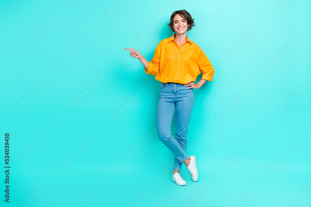 Full length photo of cute lady arm direct empty space promo big black friday sale wear trendy outfit isolated on cyan color background Full length photo of cute lady arm direct empty space promo big black friday sale wear trendy outfit isolated on cyan color background