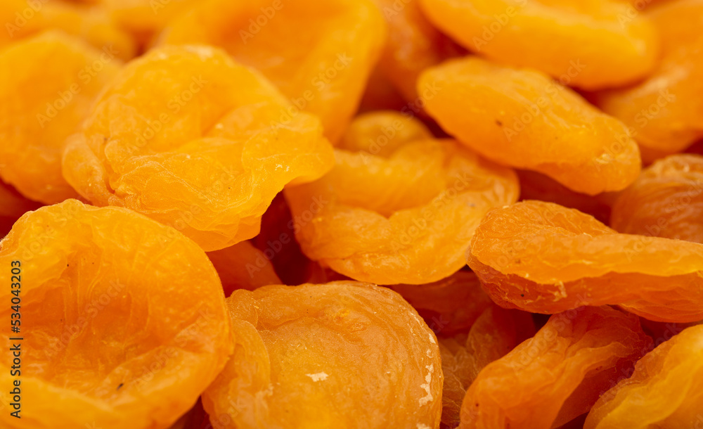 Dried apricots close up as a background. Heap of dried apricots on a white background. Dried apricots close up as a background. Heap of dried apricots on a white background.