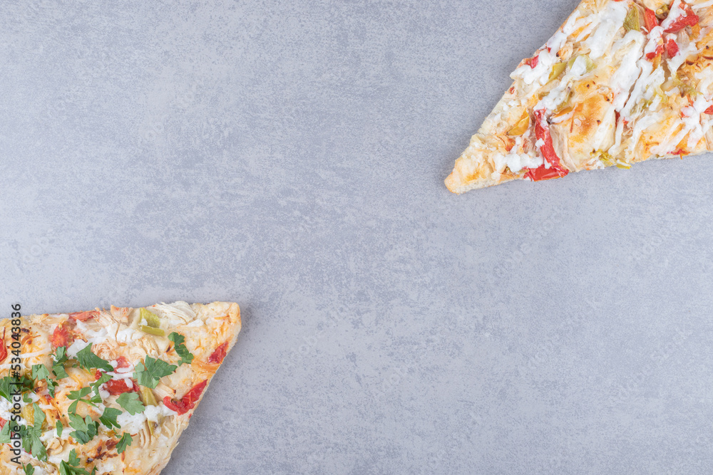 Two pizza slices displayed on marble background