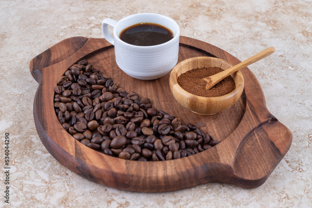 Fototapeta premium Coffee in ground, brewed and bean forms on a tray on marble background