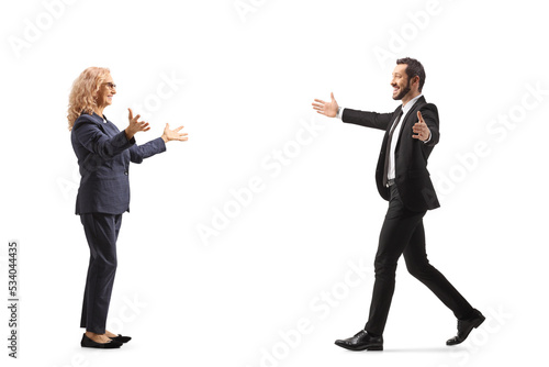 Full length profile shot of a businessman walking towards a woman with arms wide open